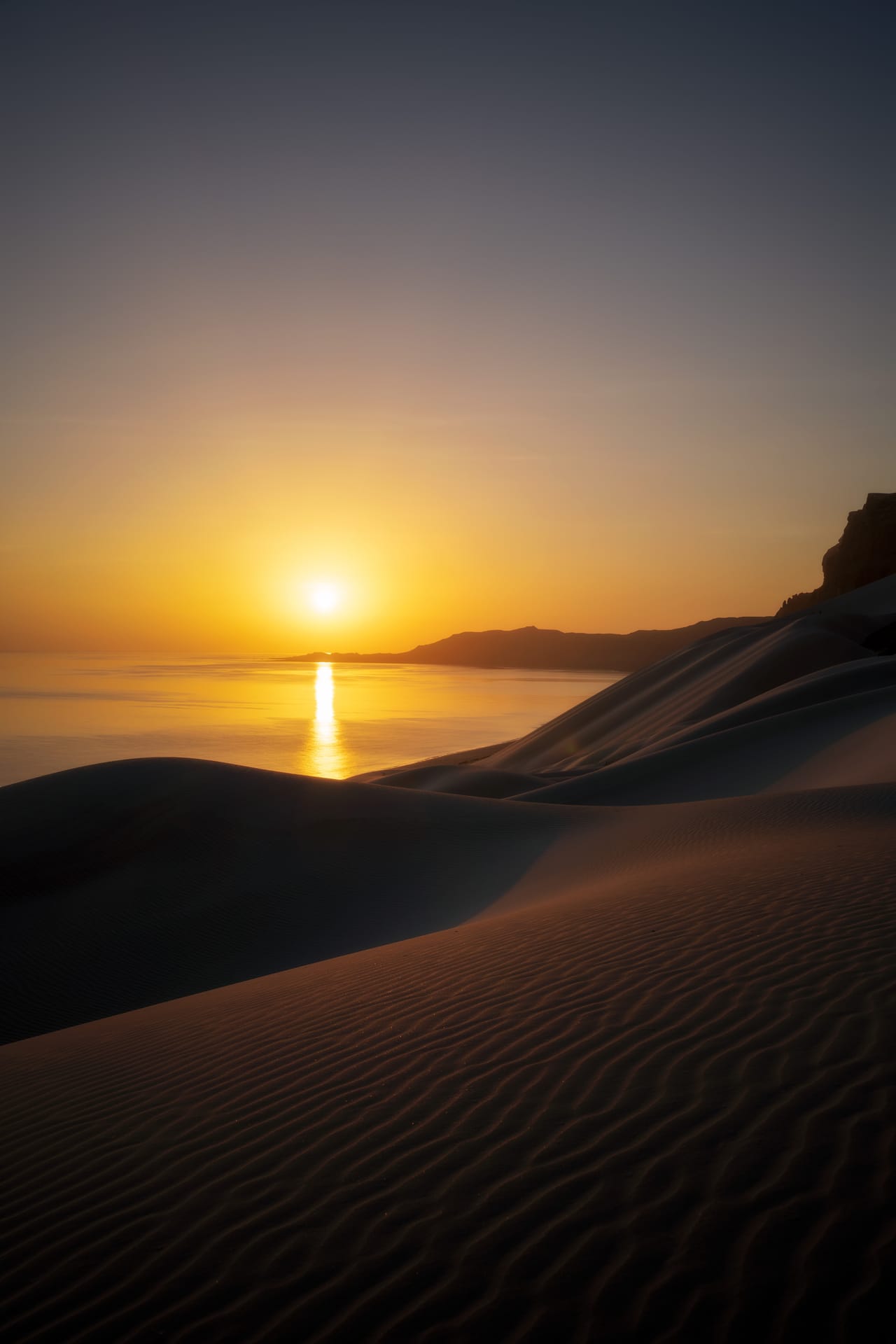 The sun setting over the sea at Arher, seen across the dunes.